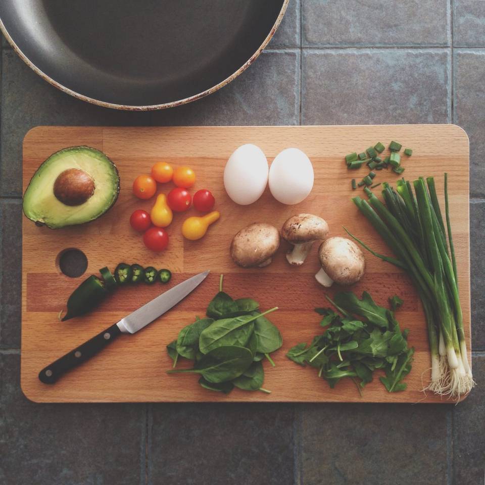Several healthy foods displayed on a cutting board with a knife.