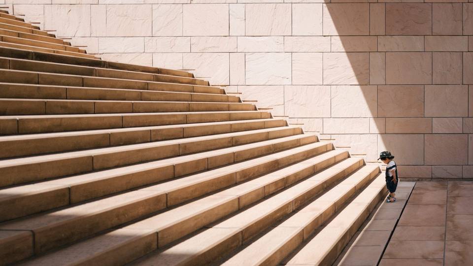 Small child in front of huge stairs.